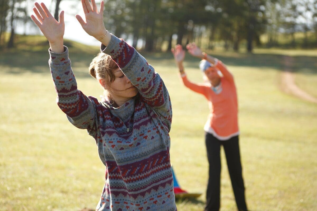 Qigong practitioner in a flowing opening posture demonstrating beginner energy cultivation